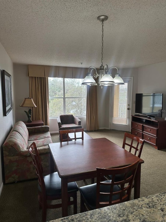 dining area with a notable chandelier, a textured ceiling, and carpet