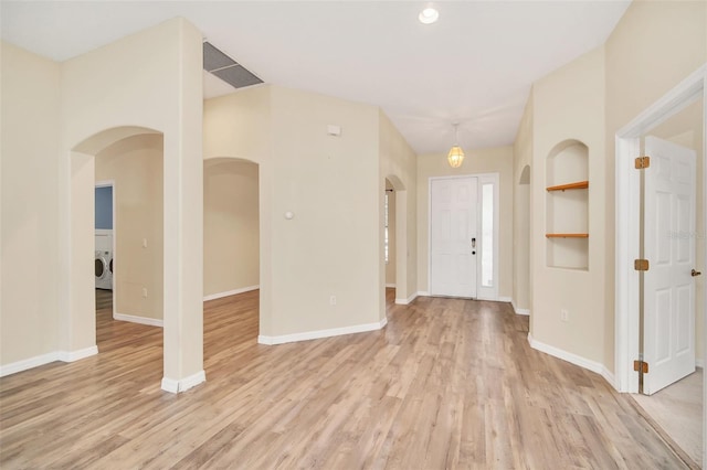 foyer entrance featuring washer / dryer and light hardwood / wood-style flooring