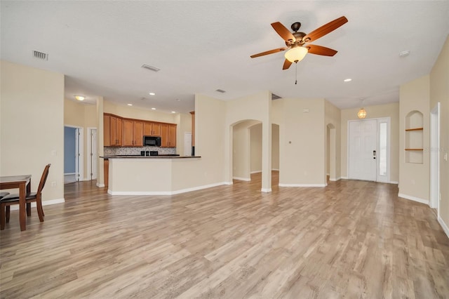 unfurnished living room with ceiling fan and light wood-type flooring