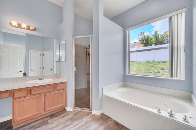 bathroom with vanity, wood-type flooring, and independent shower and bath