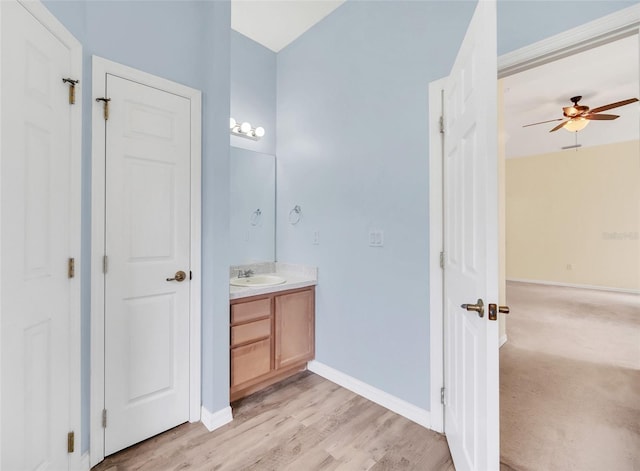 bathroom with hardwood / wood-style flooring, ceiling fan, and vanity