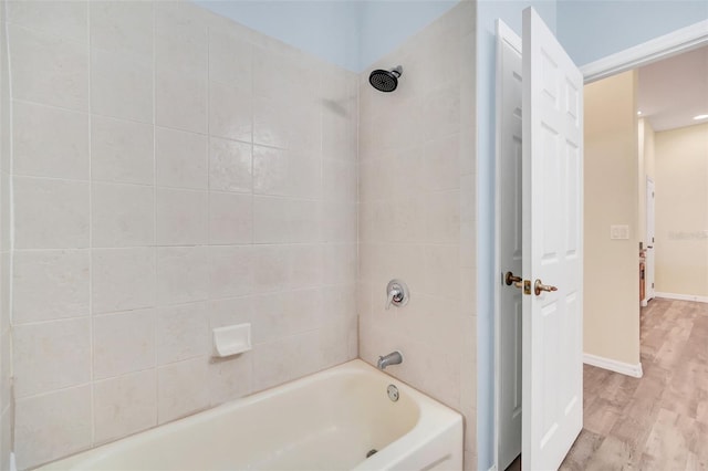 bathroom with tiled shower / bath combo and wood-type flooring