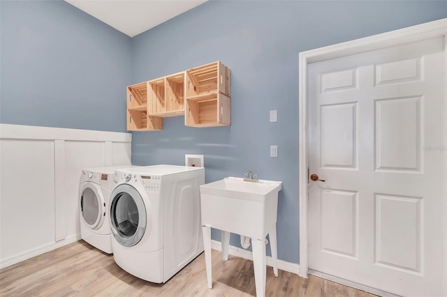 laundry area featuring washer and clothes dryer and light wood-type flooring