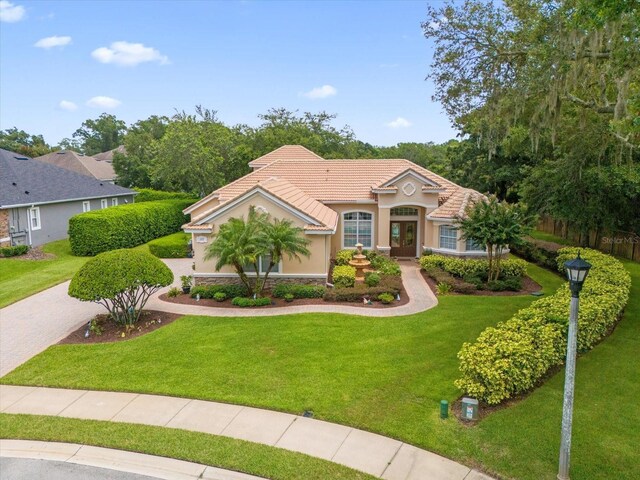 mediterranean / spanish home with a front yard