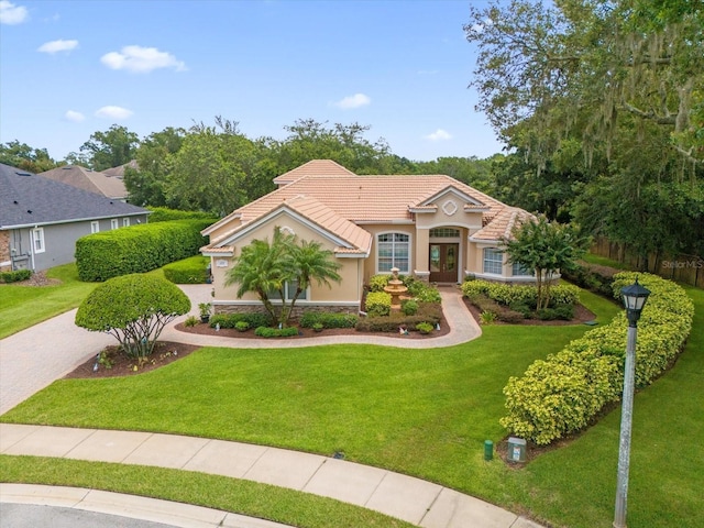 mediterranean / spanish home with a front lawn