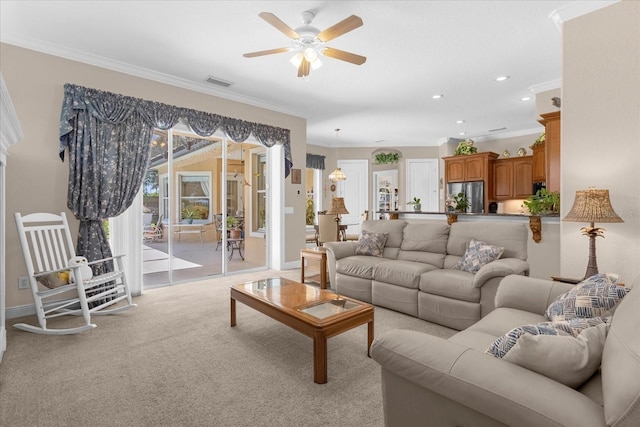 carpeted living room with crown molding and ceiling fan