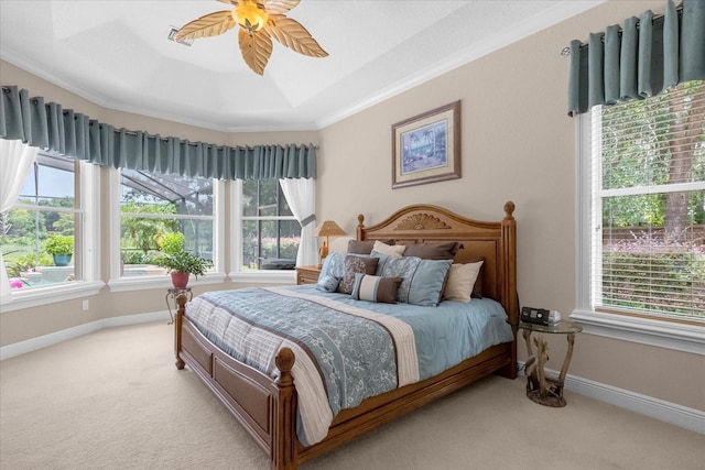 carpeted bedroom with crown molding, a raised ceiling, and ceiling fan