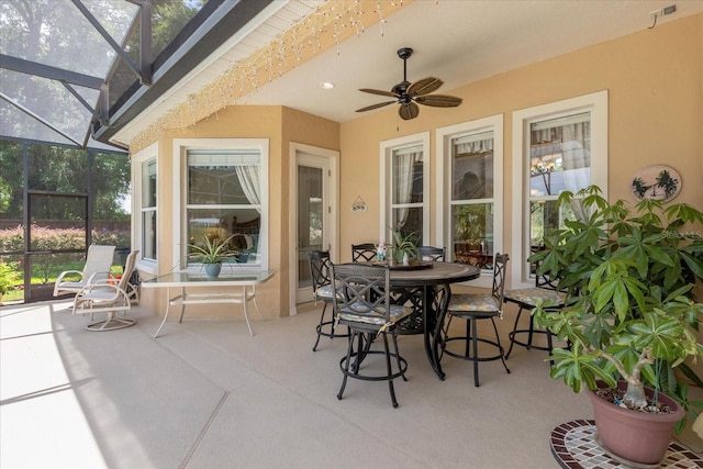 view of patio with ceiling fan and glass enclosure