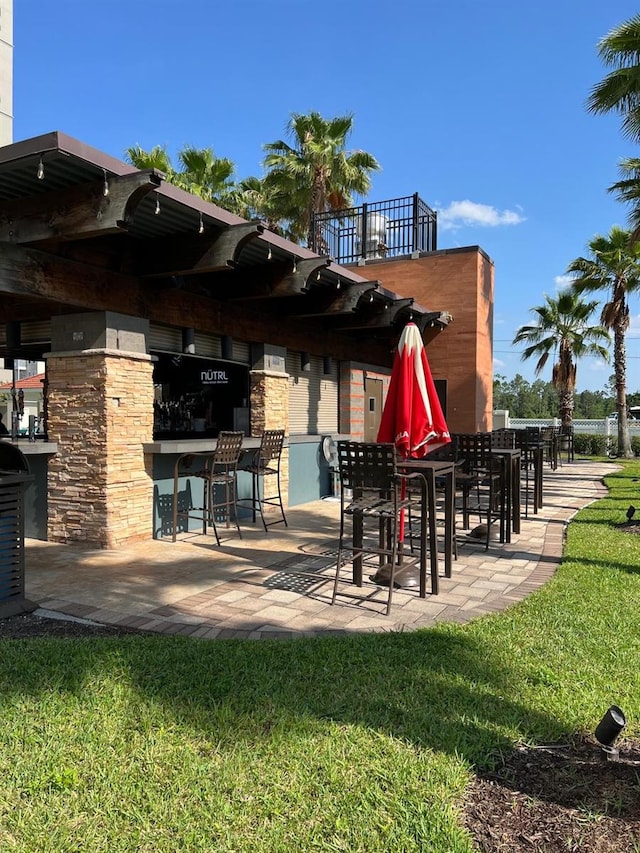 rear view of house with an outdoor bar and a lawn