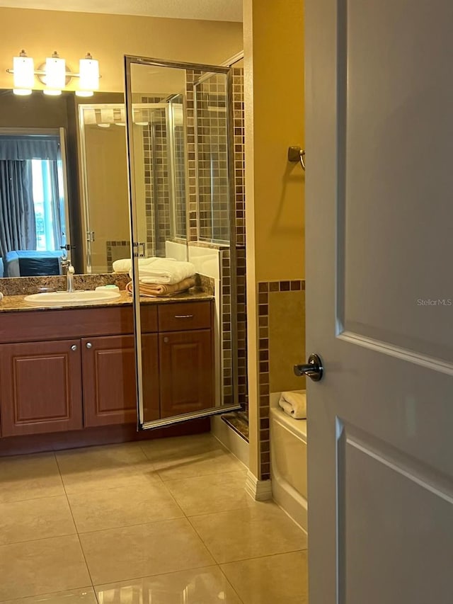 bathroom featuring a shower with shower door, vanity, and tile patterned flooring