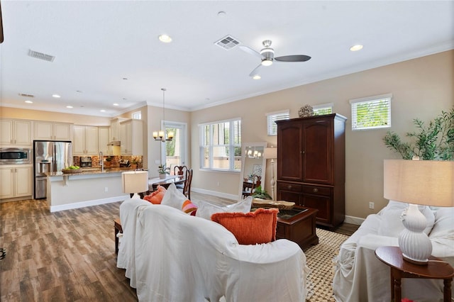 living room with crown molding, a wealth of natural light, and light hardwood / wood-style floors