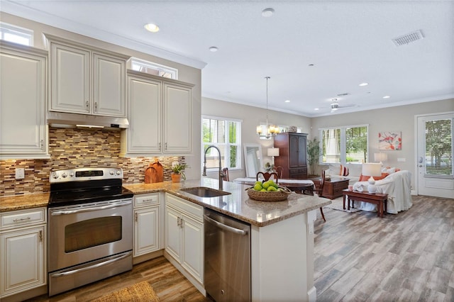 kitchen with sink, crown molding, backsplash, stainless steel appliances, and kitchen peninsula