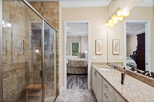 bathroom featuring ornamental molding, a shower with door, and vanity