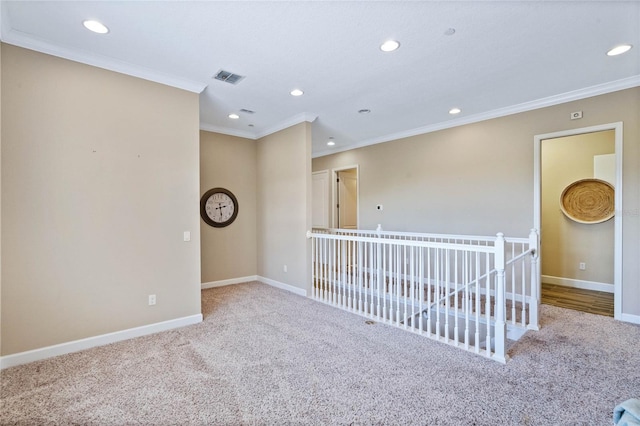 spare room with ornamental molding and light colored carpet