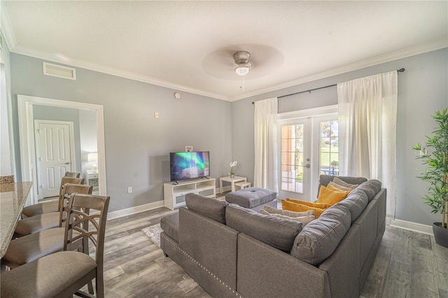 living room with ceiling fan, ornamental molding, wood-type flooring, and french doors