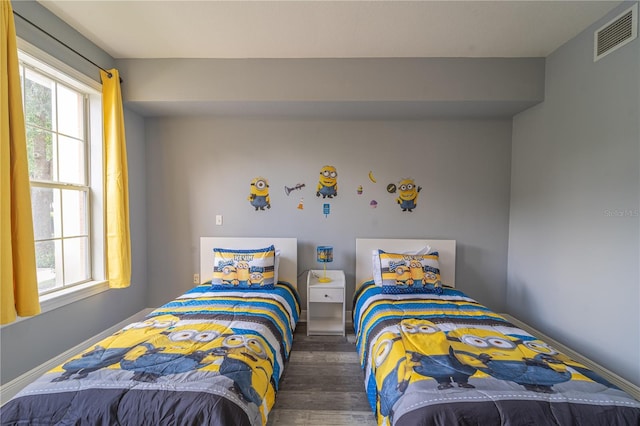 bedroom with dark hardwood / wood-style flooring and multiple windows