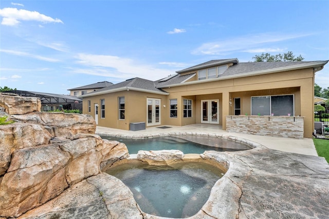 view of pool featuring an in ground hot tub, french doors, and a patio