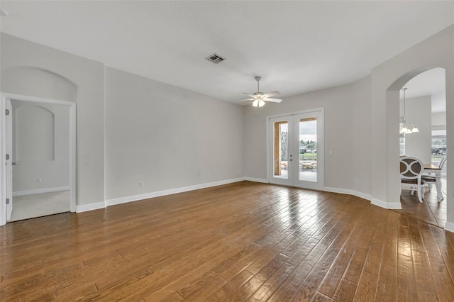 unfurnished room with wood-type flooring, ceiling fan with notable chandelier, and french doors