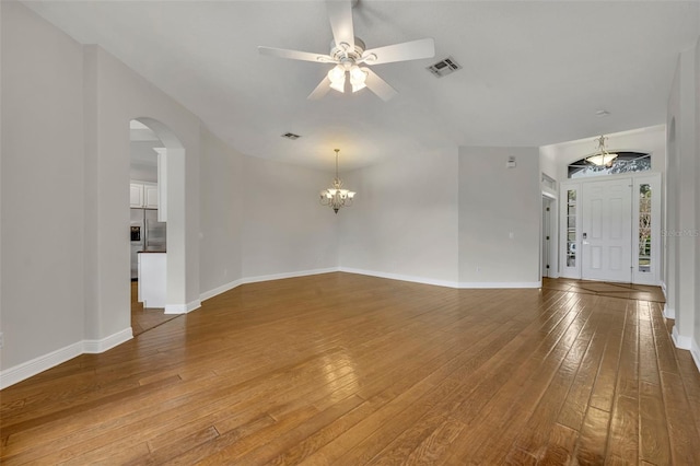 unfurnished living room with ceiling fan with notable chandelier and wood-type flooring