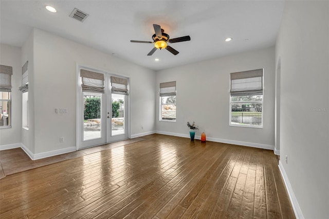 empty room with ceiling fan, dark hardwood / wood-style flooring, and french doors