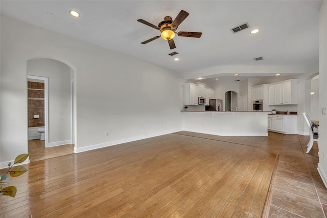 unfurnished living room with ceiling fan and light wood-type flooring