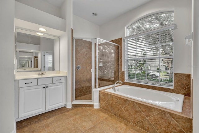 bathroom featuring tile patterned flooring, vanity, and plus walk in shower