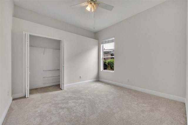 unfurnished bedroom featuring light carpet, a closet, and ceiling fan