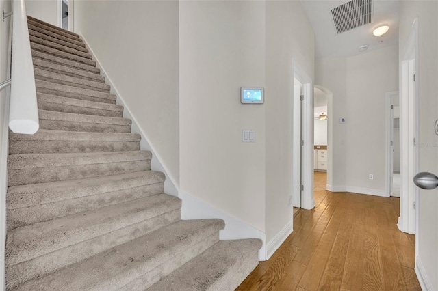 stairs featuring hardwood / wood-style floors