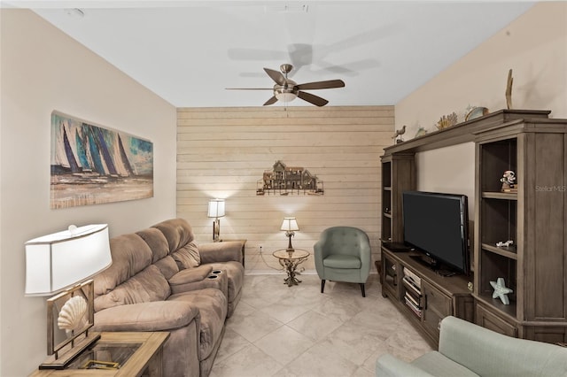 living room featuring ceiling fan and wooden walls