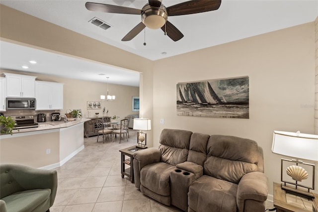 living room featuring light tile patterned flooring and ceiling fan with notable chandelier