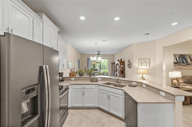 kitchen featuring sink, white cabinets, hanging light fixtures, kitchen peninsula, and stainless steel appliances