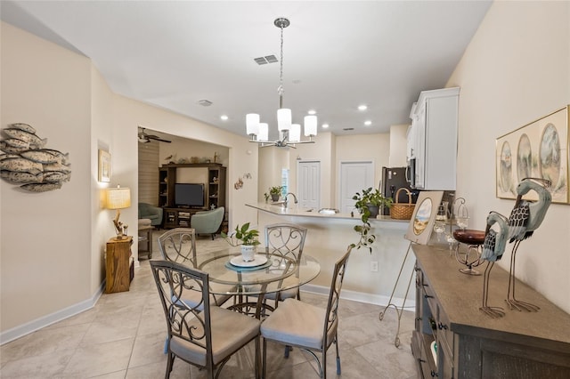 dining room with light tile patterned floors and ceiling fan with notable chandelier