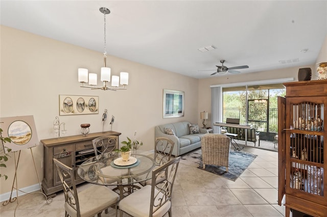 tiled dining space with ceiling fan with notable chandelier