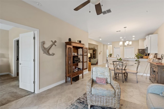 living room featuring ceiling fan with notable chandelier and light tile patterned floors