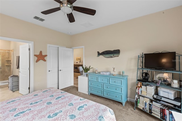 bedroom with ensuite bath, light colored carpet, and ceiling fan