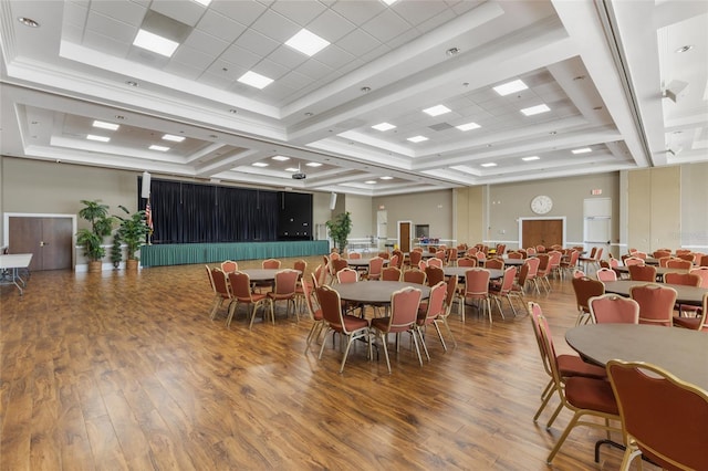 dining room with wood-type flooring, coffered ceiling, and a tray ceiling