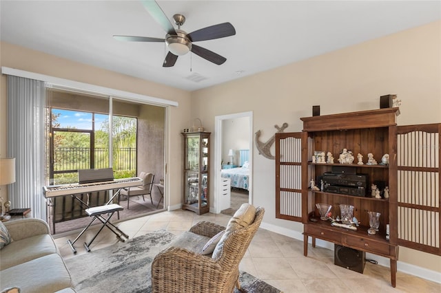 interior space featuring light tile patterned flooring, a ceiling fan, and baseboards