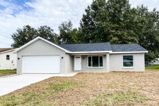 single story home featuring a garage and a front lawn