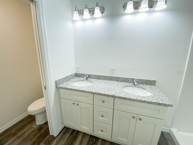 bathroom with vanity, wood-type flooring, and toilet