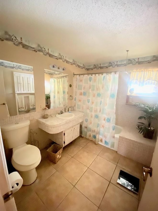 full bathroom featuring shower / bath combo with shower curtain, a textured ceiling, toilet, tile patterned floors, and vanity