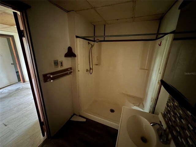 bathroom featuring sink, hardwood / wood-style flooring, and a drop ceiling