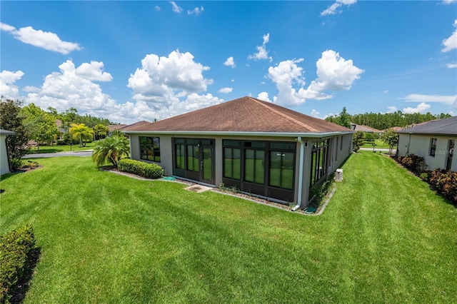 rear view of property with a yard and a sunroom