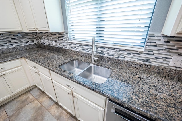 kitchen featuring sink, white cabinetry, and dark stone counters