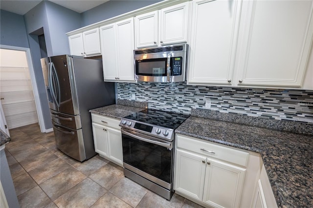 kitchen with white cabinets, decorative backsplash, dark stone counters, and appliances with stainless steel finishes