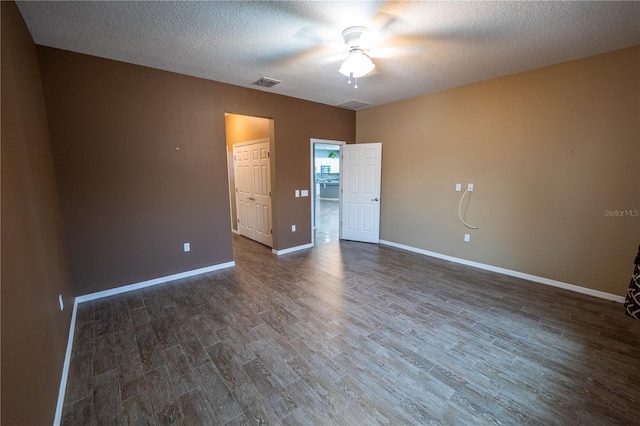 spare room with ceiling fan, a textured ceiling, and dark hardwood / wood-style flooring