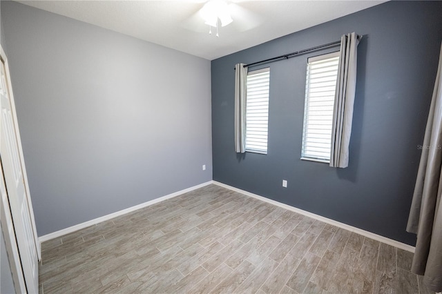 spare room featuring light hardwood / wood-style flooring and ceiling fan