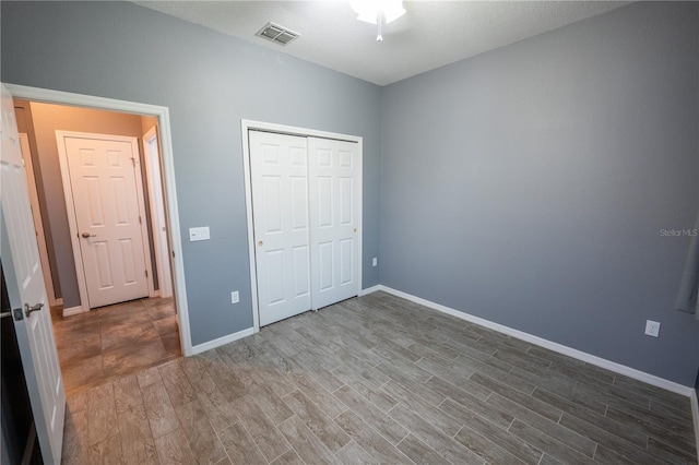 unfurnished bedroom with hardwood / wood-style flooring and a closet