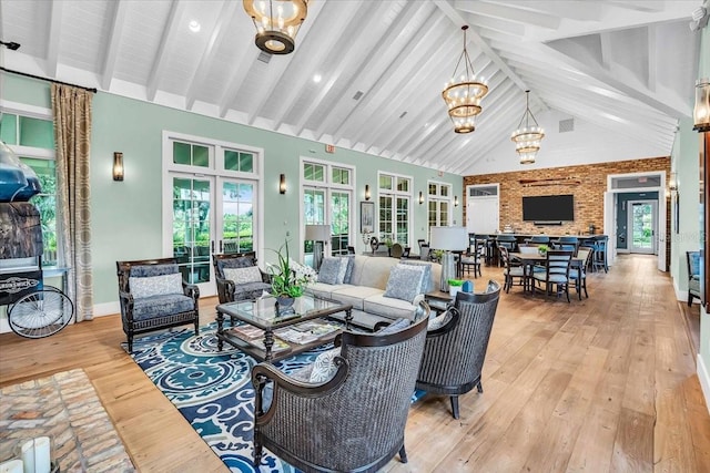 living room featuring light hardwood / wood-style flooring, a chandelier, beamed ceiling, and high vaulted ceiling