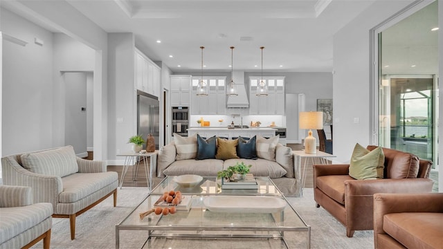 living room featuring an inviting chandelier, light hardwood / wood-style flooring, and ornamental molding