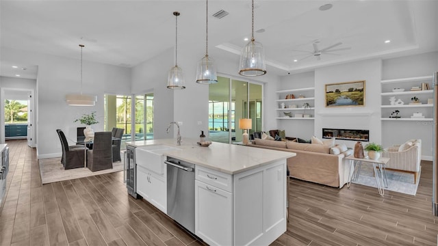 kitchen featuring stainless steel dishwasher, white cabinetry, ceiling fan, and hardwood / wood-style flooring